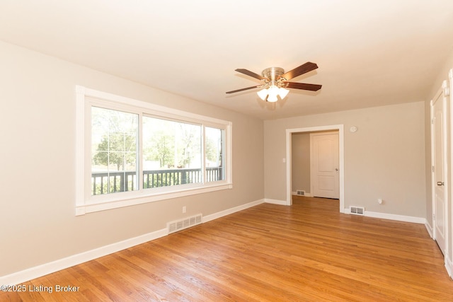 empty room with ceiling fan, visible vents, baseboards, and light wood-style flooring