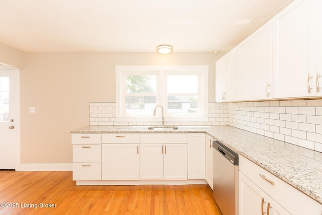 kitchen featuring light wood-type flooring, a sink, light stone counters, decorative backsplash, and dishwasher