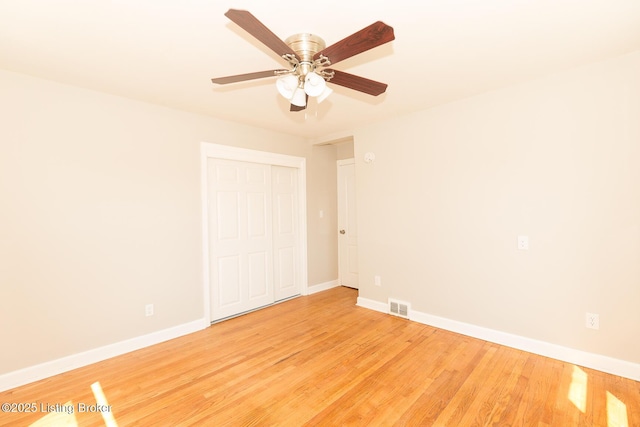 spare room with visible vents, baseboards, light wood-style floors, and ceiling fan