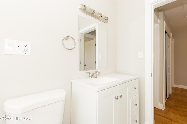 bathroom featuring vanity, toilet, and wood finished floors