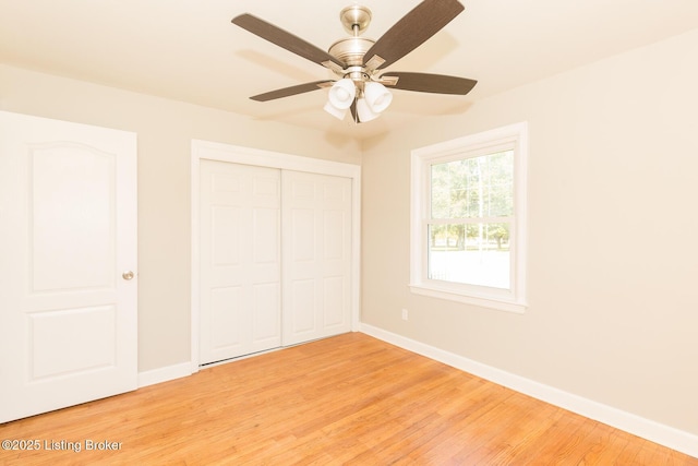 unfurnished bedroom with light wood-style floors, baseboards, a closet, and ceiling fan