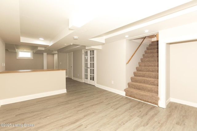 below grade area featuring recessed lighting, baseboards, wood finished floors, and stairs