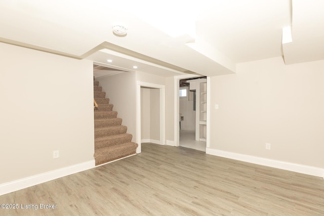 finished below grade area with recessed lighting, baseboards, stairs, and light wood-style floors