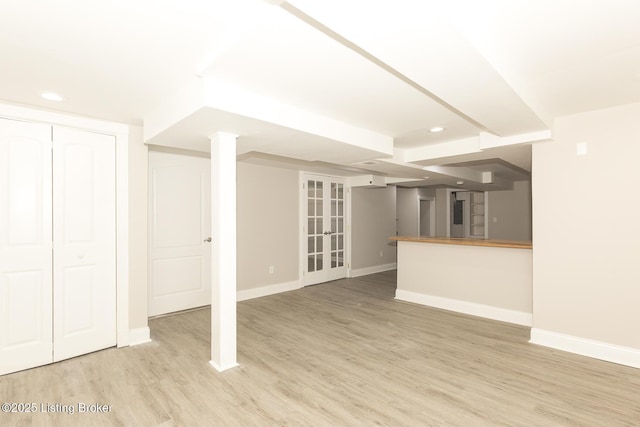 unfurnished living room with light wood-style floors, baseboards, and french doors