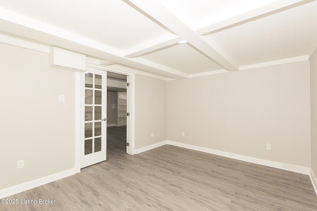 spare room with beamed ceiling, baseboards, and wood finished floors