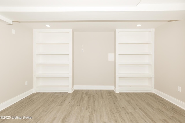 interior space with baseboards and wood finished floors