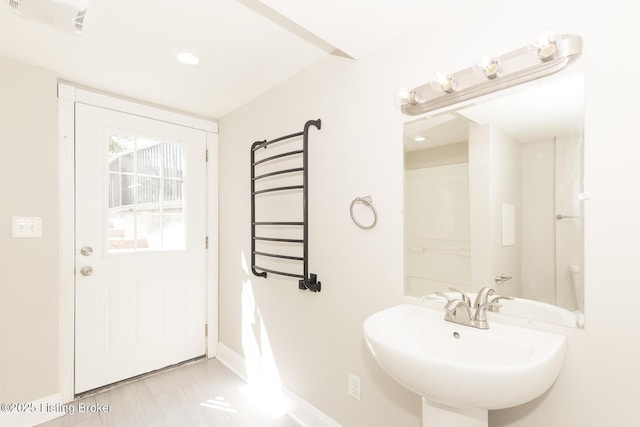 bathroom featuring a sink, baseboards, and radiator