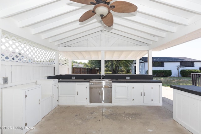 view of patio / terrace with ceiling fan, exterior kitchen, and fence