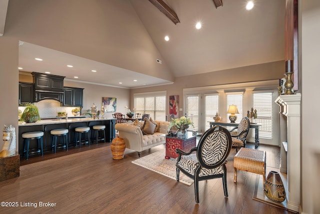 living room with beam ceiling, high vaulted ceiling, ornamental molding, wood finished floors, and recessed lighting