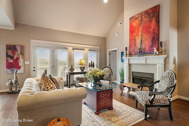 living area featuring a fireplace, baseboards, and wood finished floors