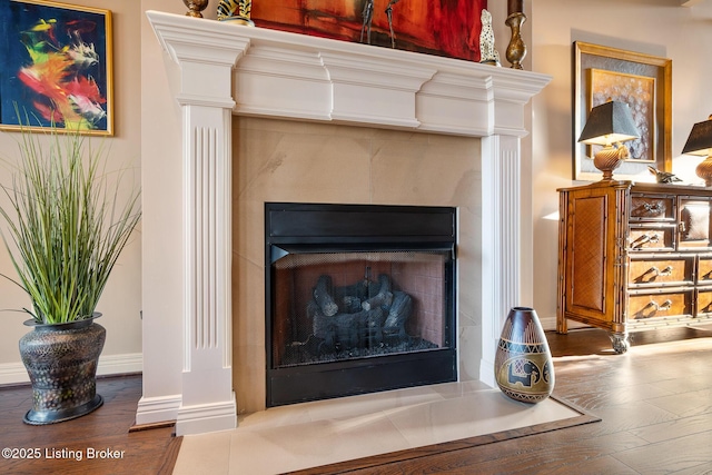 room details with a fireplace, wood finished floors, and ornate columns