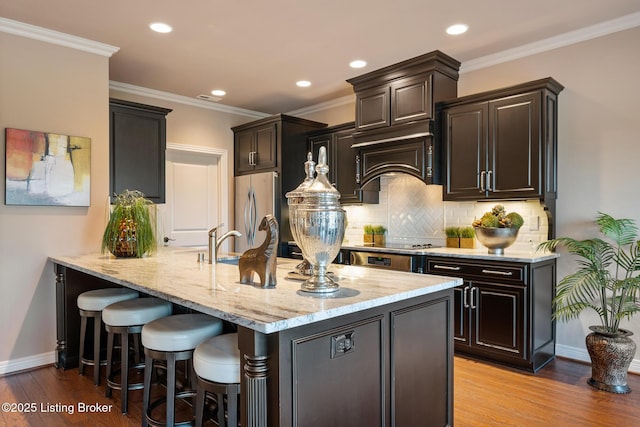 kitchen featuring decorative backsplash, light wood-style floors, ornamental molding, and freestanding refrigerator