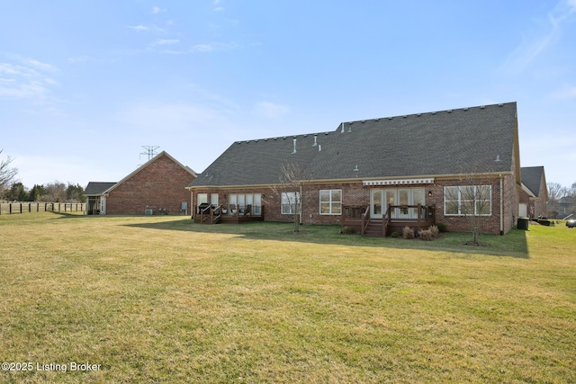 rear view of house featuring a yard and brick siding