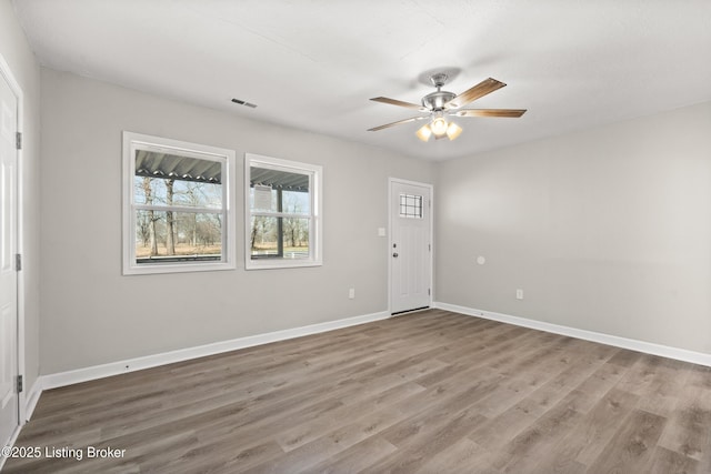 foyer featuring visible vents, wood finished floors, baseboards, and ceiling fan