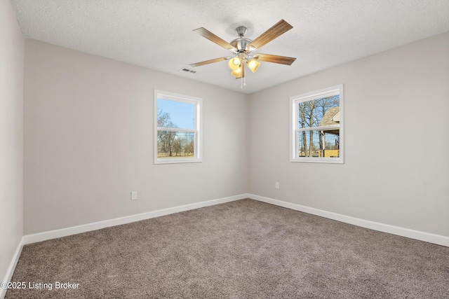 carpeted spare room featuring baseboards and a textured ceiling