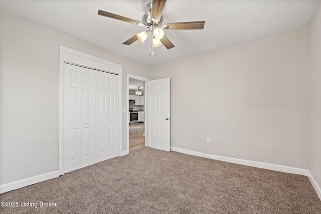 unfurnished bedroom featuring a closet, baseboards, a textured ceiling, and carpet flooring