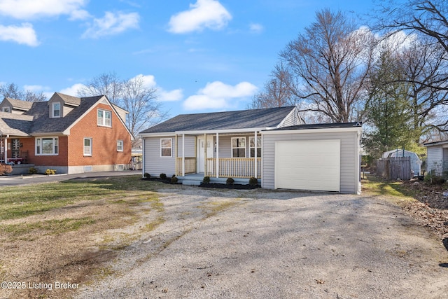 view of front facade featuring a porch, driveway, and a garage