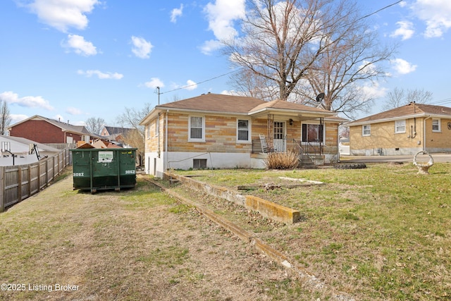 back of house featuring a lawn and fence