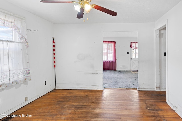 empty room with a ceiling fan and wood-type flooring