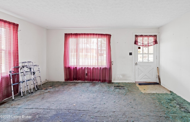 carpeted entrance foyer with a textured ceiling