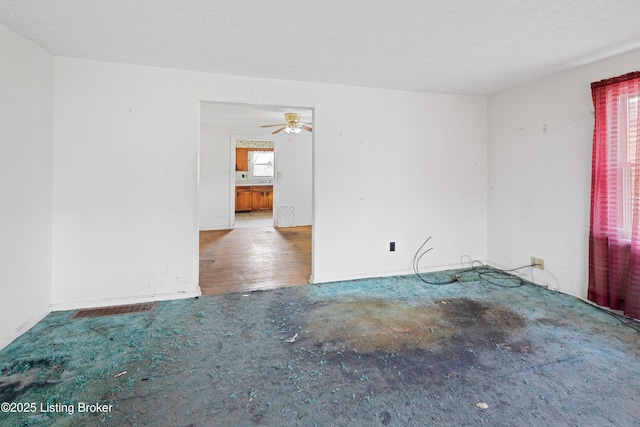 spare room featuring a textured ceiling and a ceiling fan