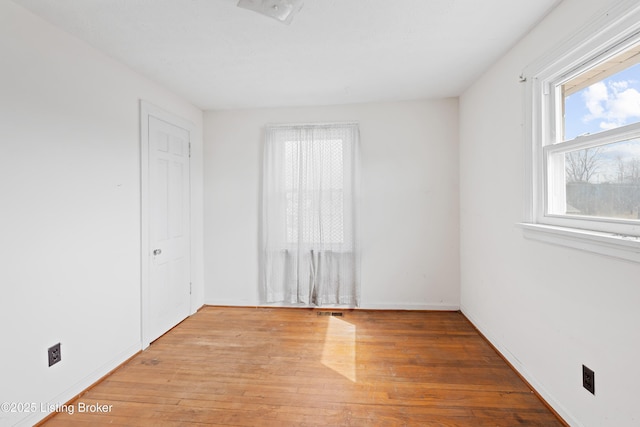 empty room featuring visible vents and light wood-type flooring