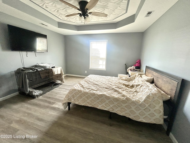 306 Oak Hill Ct, Bardstown, KY 40004 - bedroom featuring a tray ceiling, baseboards, visible vents, and wood finished floors
