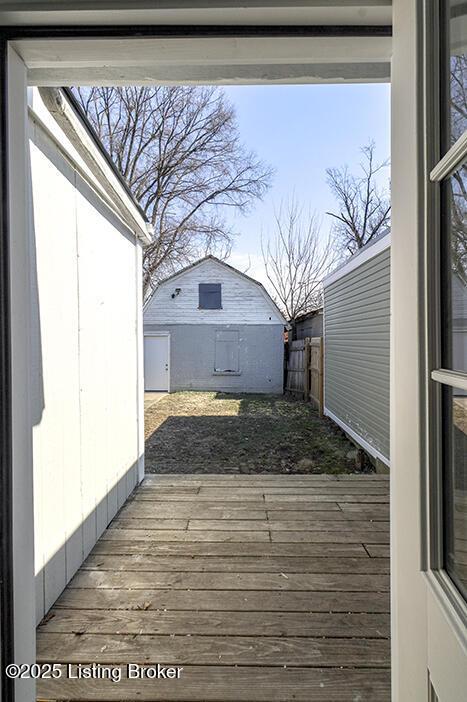 deck featuring fence, an outbuilding, and a shed