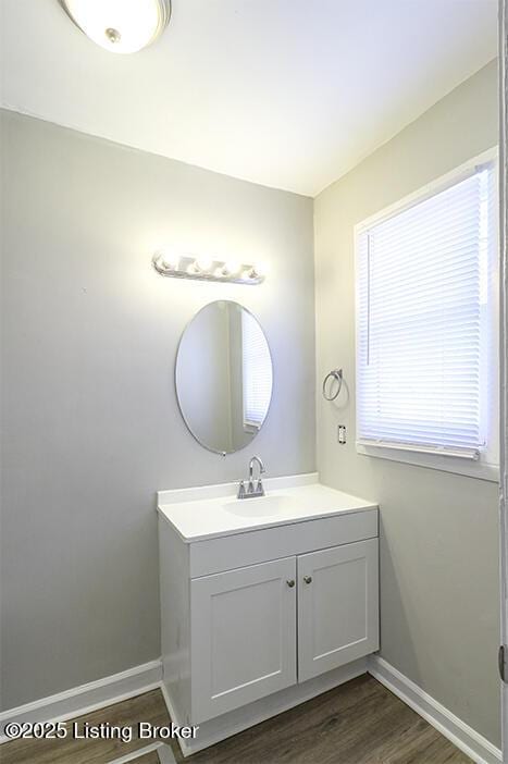 bathroom with baseboards, wood finished floors, and vanity