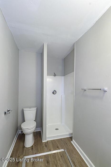 full bath with baseboards, toilet, walk in shower, and wood finished floors