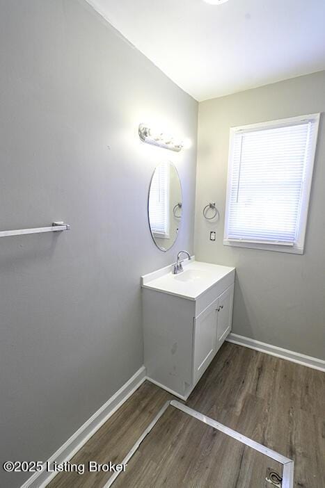 bathroom featuring vanity, wood finished floors, and baseboards