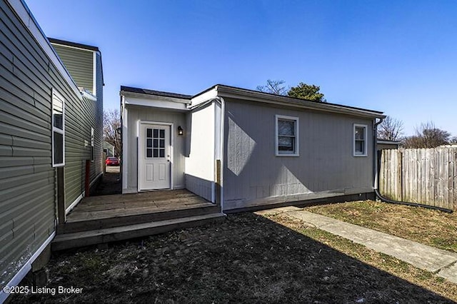 rear view of house featuring fence