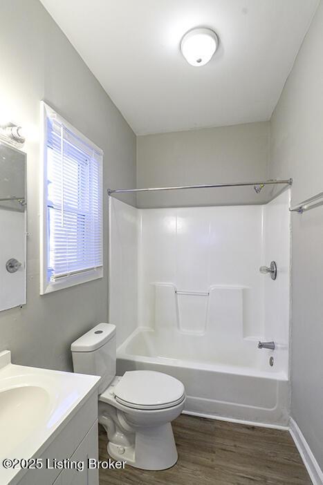 bathroom featuring vanity, toilet, shower / bath combination, and wood finished floors