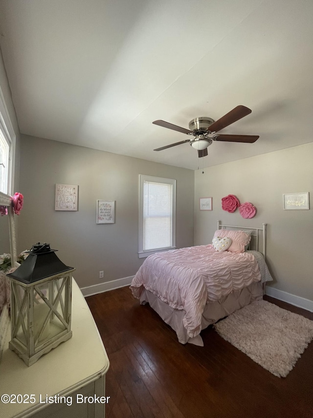 bedroom with ceiling fan, dark wood-type flooring, and baseboards