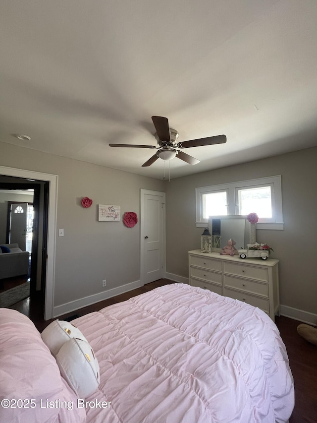 bedroom featuring a ceiling fan, dark wood-style floors, and baseboards