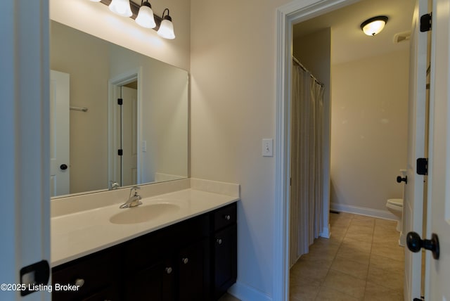 bathroom with toilet, tile patterned floors, vanity, and baseboards