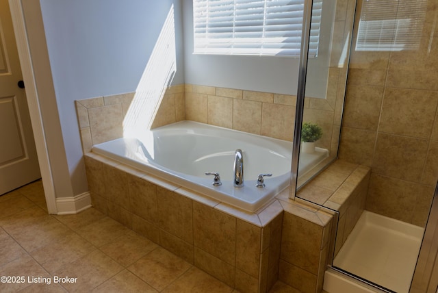 bathroom featuring tile patterned floors, a garden tub, and a tile shower