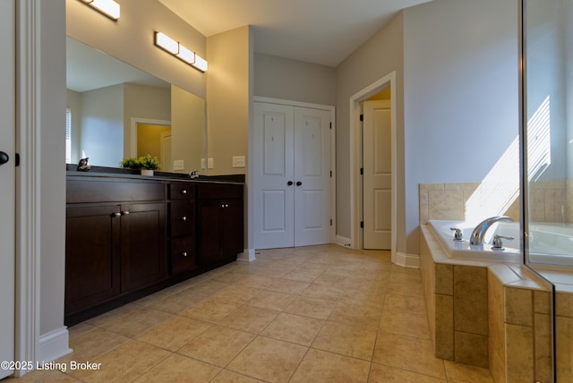 full bath featuring tile patterned floors, baseboards, a bath, and vanity