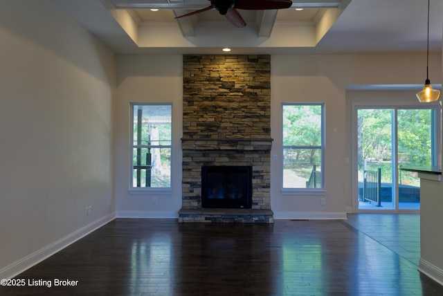 unfurnished living room featuring a fireplace, plenty of natural light, a ceiling fan, and dark wood-style floors