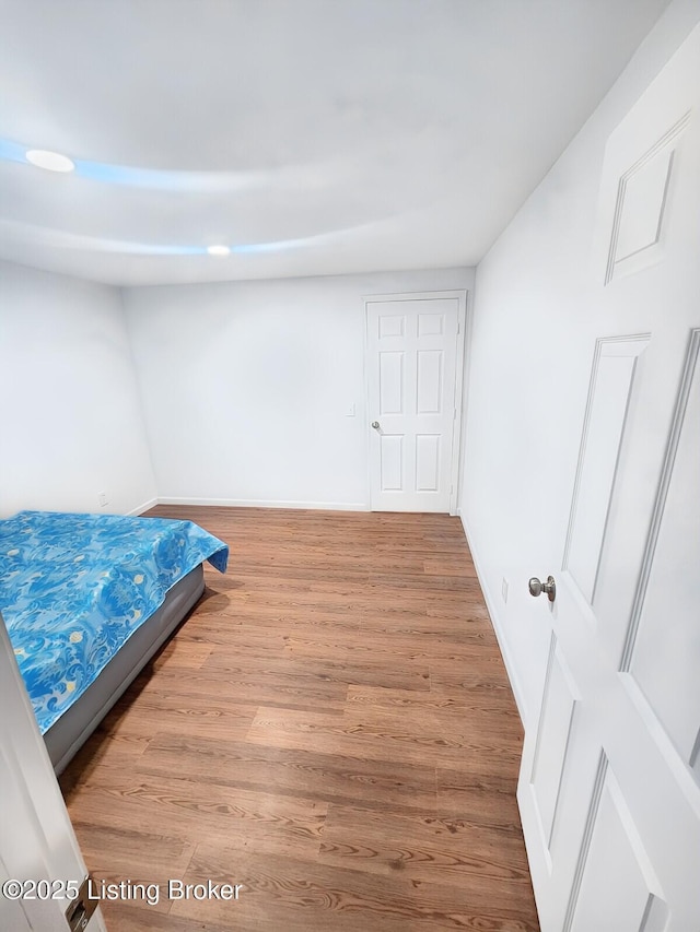 bedroom featuring baseboards and wood finished floors