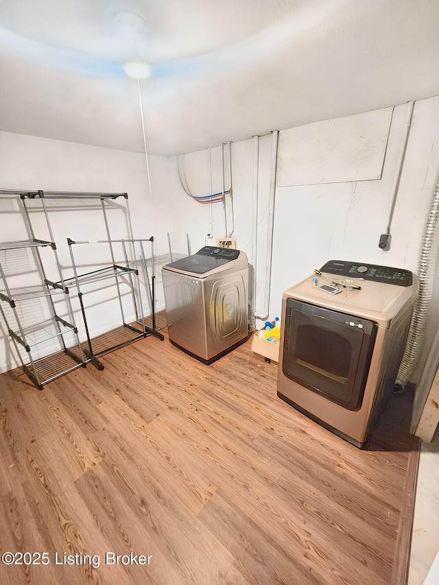 washroom with electric dryer hookup, light wood-style flooring, and laundry area