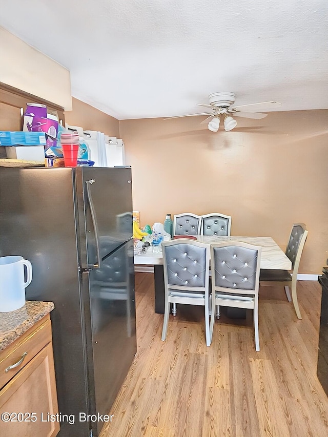 kitchen with ceiling fan, freestanding refrigerator, and light wood-style floors