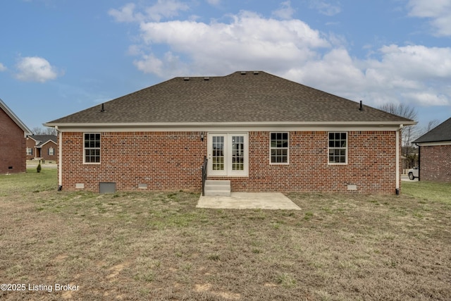 back of house with a lawn, roof with shingles, and brick siding