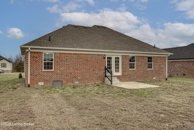 rear view of house featuring entry steps, a yard, roof with shingles, crawl space, and brick siding