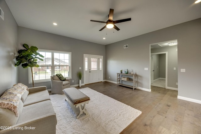 living room featuring visible vents, baseboards, ceiling fan, and wood finished floors