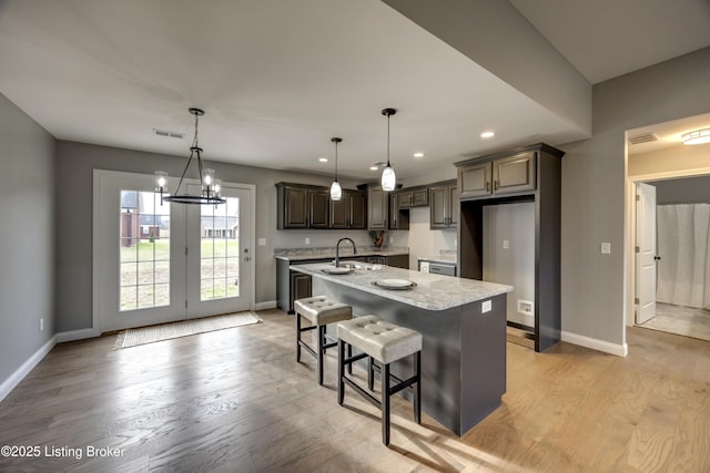 kitchen featuring light wood-style floors, baseboards, and a sink