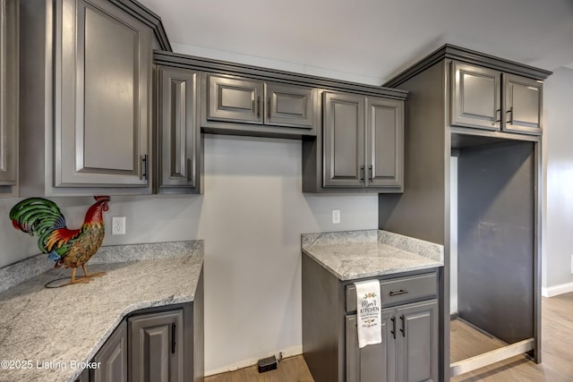 kitchen with baseboards, light wood-style floors, and gray cabinetry