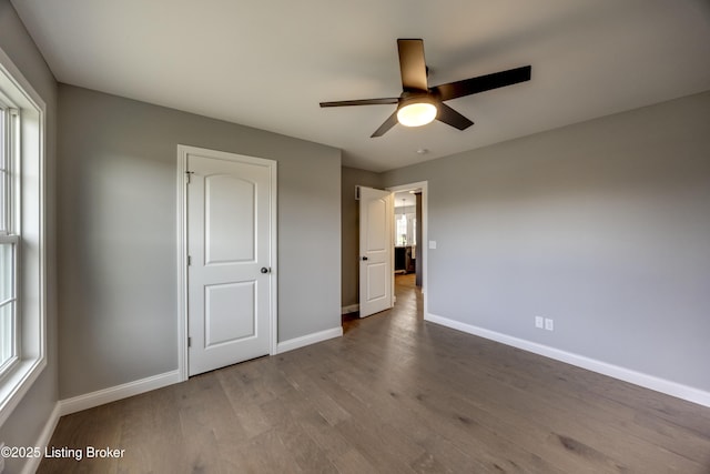 unfurnished bedroom with a ceiling fan, baseboards, and wood finished floors