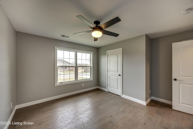 unfurnished bedroom featuring visible vents, ceiling fan, baseboards, and wood finished floors