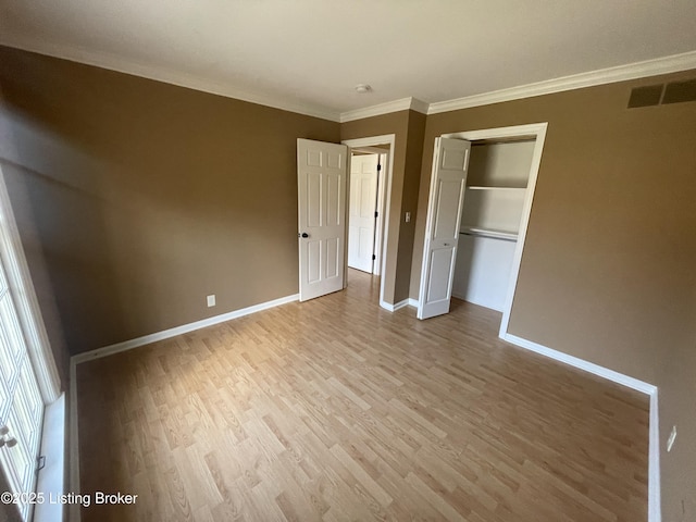 unfurnished bedroom featuring baseboards, visible vents, light wood-style floors, a closet, and crown molding